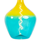 Close-up hanglamp met amber bovenkant en teal glazen kap, gloeiende gloeidraad.