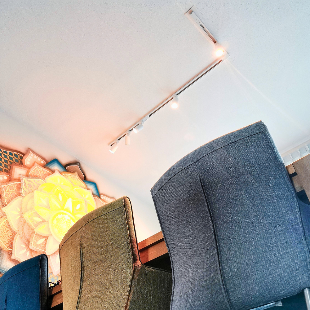 Witte railverlichting op plafond met meerdere warmlicht spots