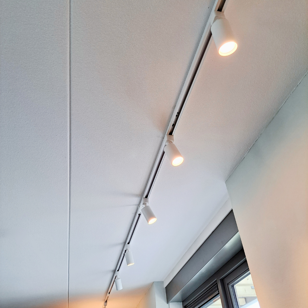 Wit plafondrail met meerdere spots langs 1-fase railsysteem