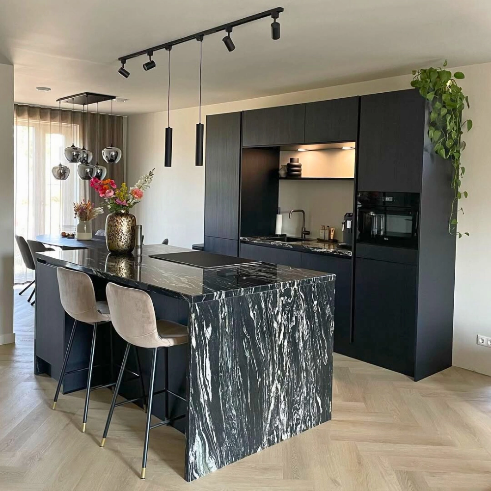 Zwarte plafondrail met drie spots en twee hanglampen in moderne keuken