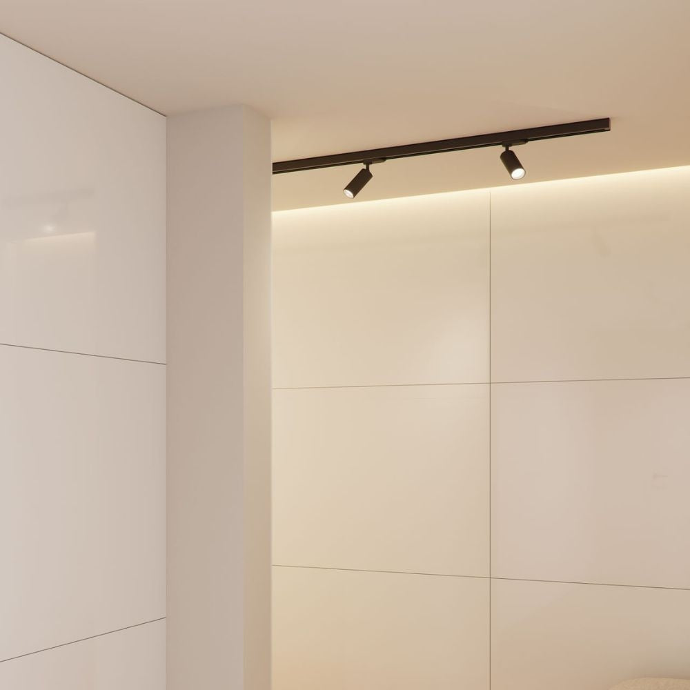 Zwarte rail met LED-spots op plafond; strak en minimalistisch